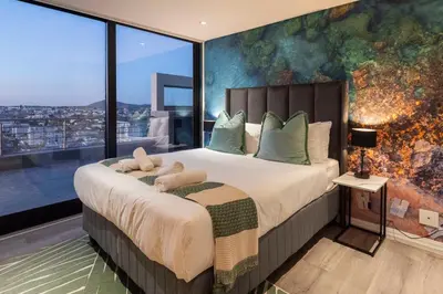 a bedroom with a large bed with a large window at Penthouse with a view to die for! in Cape Town