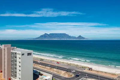 a view of the ocean with mountains in the background at Penthouse with a view to die for! in Cape Town