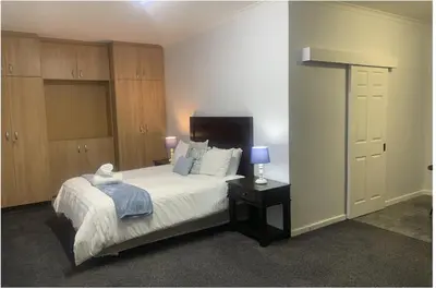 a bedroom with a bed and a table with a lamp at Table Mountain Views in Cape Town