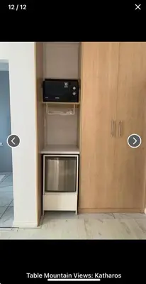 a kitchen with a microwave and a cabinet at Table Mountain Views in Cape Town