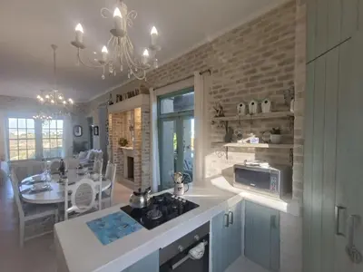 a kitchen with a sink and a stove top oven at KLIPWERF Bettys Bay in Bettyʼs Bay
