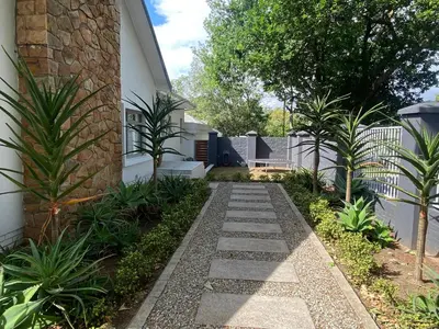 a garden with a stone walkway next to a building at 33 Tafelberg! in Cape Town