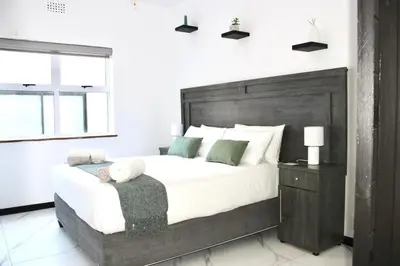 a bedroom with a large bed with a teddy bear on it at Sea and Mountain View Apartment in Cape Town