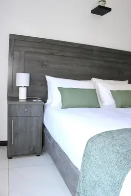 a bedroom with a large bed with a wooden headboard at Sea and Mountain View Apartment in Cape Town