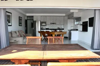 a dining room and kitchen with a table and chairs at Sea and Mountain View Apartment in Cape Town