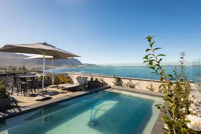 a swimming pool with a view of the water at Studio 7 - Hermanus Waterfront Apartments in Hermanus