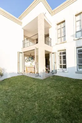 a large white house with a grass yard at Waddle Inn Luxury apartment in Franschhoek in Franschhoek