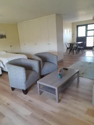 a living room with two chairs and a coffee table at Luxury Studio sleeps up to 3 adults - Sunset Beach in Cape Town