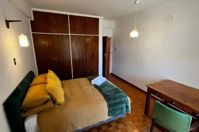 a bed in a room with a desk and a table at Retro City Center Gem by ARPA Hospitalities in Stellenbosch