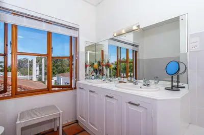a bathroom with two sinks and a large mirror at Fynbos House in Hermanus