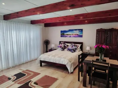 a bedroom with a bed and a table and a desk at Villa Rosa Luxury in Cape Town