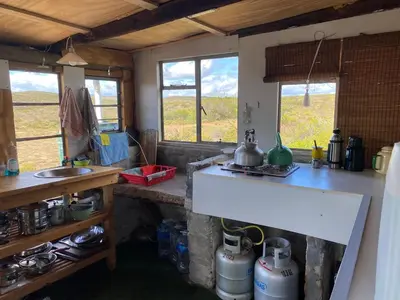 a kitchen with a counter and a sink and two windows at Skuilkrans Private Nature Reserve in McGregor
