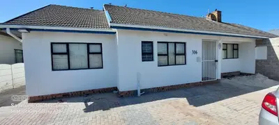 a white house with a blue roof at COMFORT LODGE milnerton, Cape Town in Cape Town