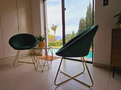 two green chairs sitting in a room with a window at Die Regte Rede in Cape Town