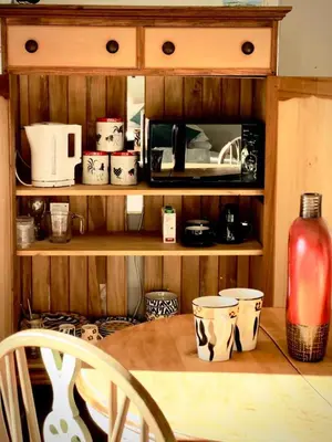 a wooden shelf with cups and a coffee maker at Guest Suite in Tuscan Farmhouse in Paarl