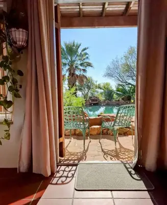an open door to a patio with a view of a pool at Guest Suite in Tuscan Farmhouse in Paarl