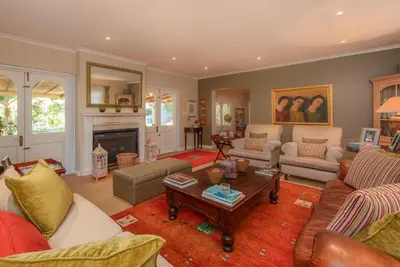 a living room with couches and a fireplace at Beautiful country house set in lush garden in Wellington