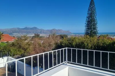 a view from the balcony of a house at Beautiful 4 bedroom home overlooking the ocean in Somerset West Cape Town in Cape Town