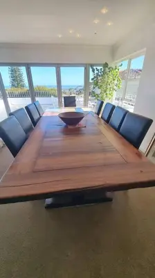 a large wooden table with chairs around it in a room at Beautiful 4 bedroom home overlooking the ocean in Somerset West Cape Town in Cape Town