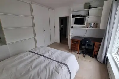 a bedroom with a bed and a desk and a computer at Beautiful 4 bedroom home overlooking the ocean in Somerset West Cape Town in Cape Town