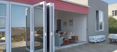a living room with sliding glass doors on a house at Red Disa in Malkopvlei