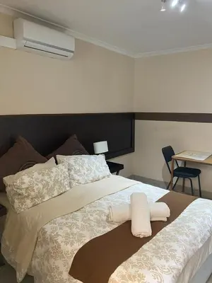 a bedroom with a bed with two towels on it at Delash Pine Villa in Cape Town
