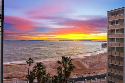 a view of the beach at sunset from a building at Elana Beachfront Condo in Strand