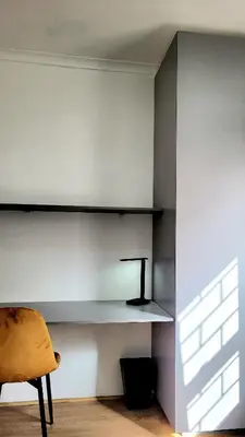 a room with a shelf on the wall with a chair at Aeon Nest in Parow