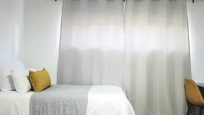 a bedroom with a bed with a yellow pillow on it at Aeon Nest in Parow