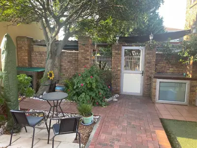 a patio with a table and chairs and a door at Morrison Hotel in Parklands