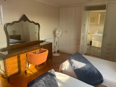 a bedroom with a mirror and a bed and a chair at Morrison Hotel in Parklands