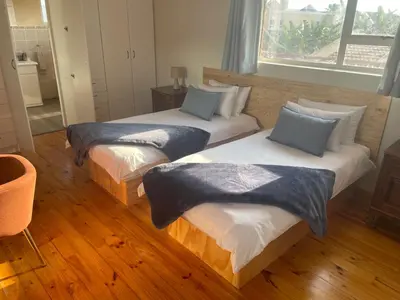 two beds in a room with wood floors at Morrison Hotel in Parklands