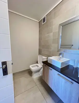 a bathroom with a white toilet and a sink at Stylish waters edge apartment in Cape Town