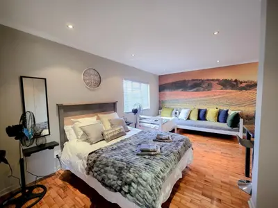 a bedroom with a large bed and a couch at Royal Boland in Paarl