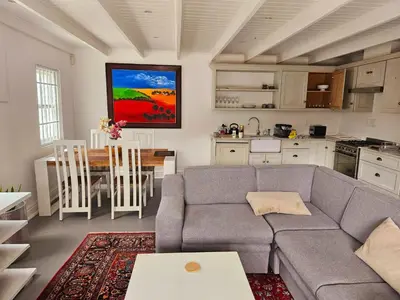 a living room with a couch and a table and a kitchen at PinotageLuxuryCollection 9A Herte Suite in Stellenbosch