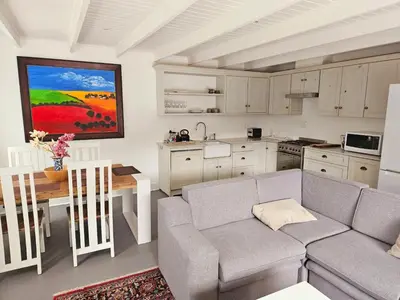 a living room with a couch and a table and a kitchen at PinotageLuxuryCollection 9A Herte Suite in Stellenbosch