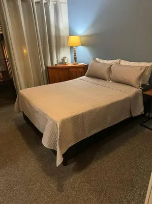 a bedroom with a bed and a lamp and a window at Holihome in Brackenfell