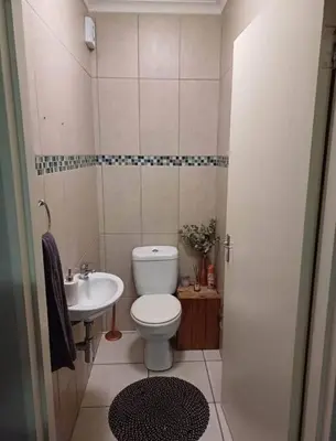 a small bathroom with a toilet and a sink at Holihome in Brackenfell