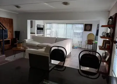 a living room with a couch and two chairs at Holihome in Brackenfell