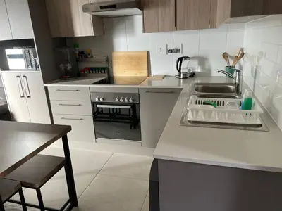 a kitchen with a sink and a stove top oven at Rozama's little nest in Cape Town