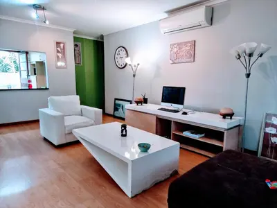 a living room with a couch and a desk with a computer at 3 bedroom garden house in Tableview in Table View