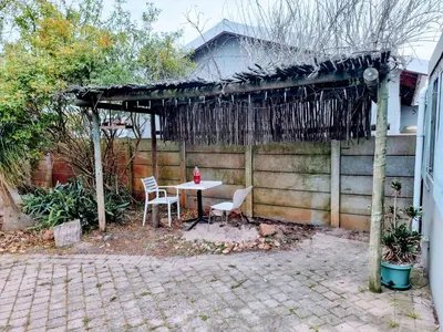 a patio with a table and chairs and a fence at 3 bedroom garden house in Tableview in Table View
