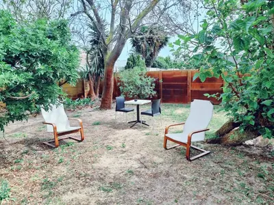 a group of chairs and a table in a yard at 3 bedroom garden house in Tableview in Table View