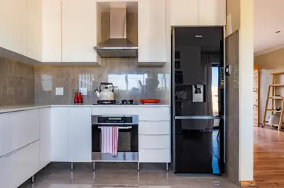 a kitchen with white cabinets and a stove at 59onLetchworth in Cape Town