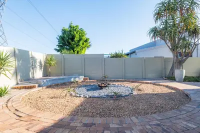 a small garden with a fountain in the middle of a yard at 59onLetchworth in Cape Town