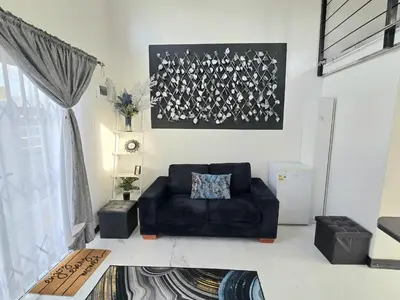 a living room with a black couch and a picture at Aqua Breeze in Cape Town