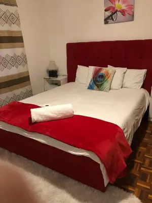 a bedroom with a large bed with a red blanket at ggu in Cape Town