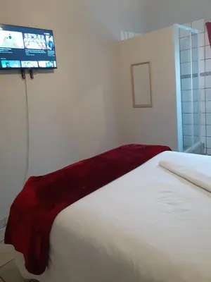 a bedroom with a bed with a red blanket on it at ggu in Cape Town