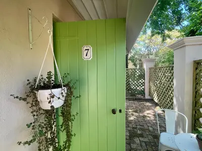 a green door with a potted plant on it at La Rose Quartier in Wellington