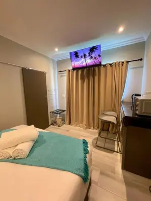 a bedroom with a bed and a flat screen tv at Tehillah on Boom in Bothasig
